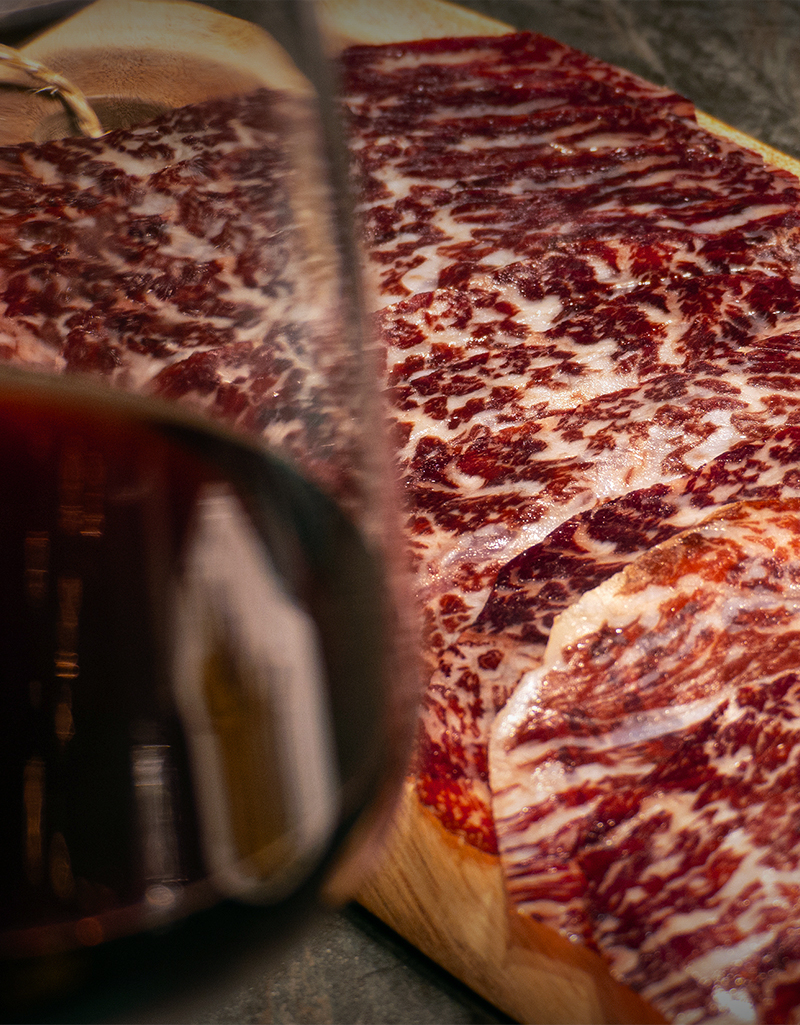 Curat Selecció Black Angus amb copa de vi a primer plà