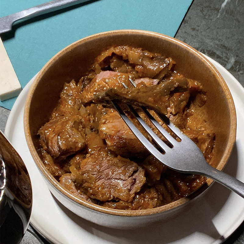 Platet de daus de filet de vedella amb rovellons i forquilla en una taula